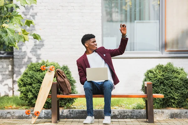 Joven Afroamericano Estudiante Usando Portátil Saludando Con Mano — Foto de Stock