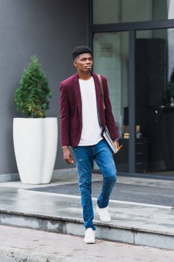 sırt çantası ve dizüstü bilgisayarlar ile yürüme yakışıklı genç öğrenci