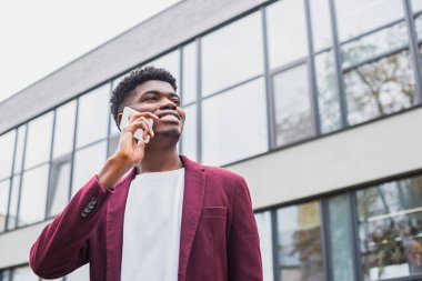 Alt görünümü genç gülümseyen, adam sokakta telefonla konuşurken ve uzağa arıyorsunuz