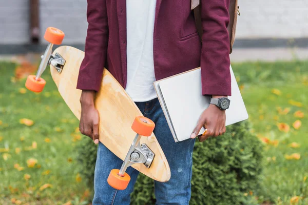 Bijgesneden Schot Van Stijlvolle Student Met Laptops Skateboard Staande Straat — Gratis stockfoto