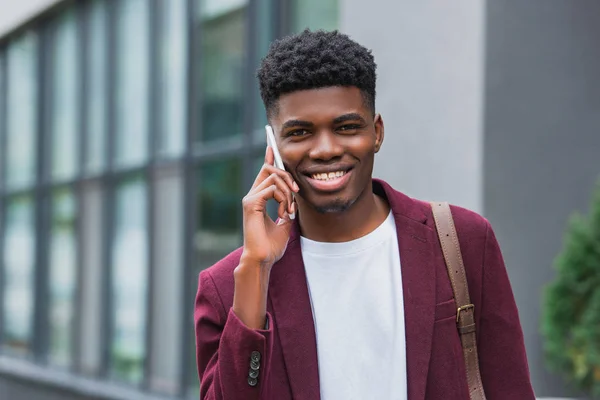 Nærbilde Smilende Ung Mann Som Snakker Telefon Gata Ser Kamera – stockfoto