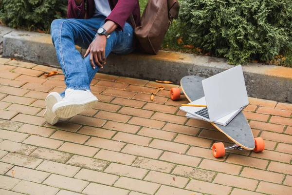 Przycięte Strzał Freelancer Siedząc Krawężniku Ulicy Pobliżu Laptopa Deskorolce — Darmowe zdjęcie stockowe