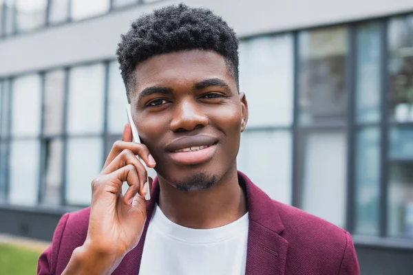 Mosolygó Fiatal Ember Beszél Telefonon Miközben Nézi Kamera Utcában — ingyenes stock fotók