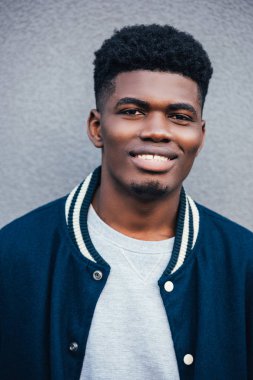 trendy mavi bombacı Afro-Amerikan erkek gülümseyen portresi 