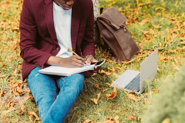 Cropped View African American Freelancer Writing Documents Working Laptop Smartphone — Stock Photo, Image