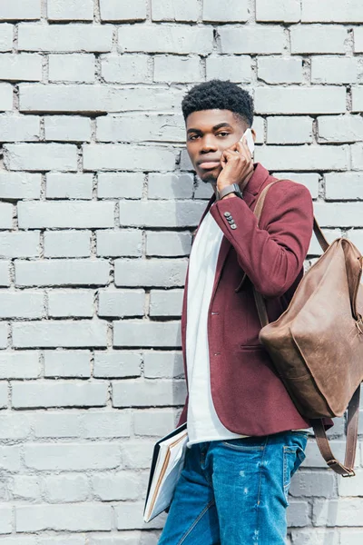 Handsome African American Man Documents Talking Smartphone White Brick Wall — Free Stock Photo