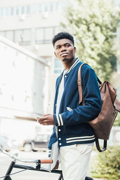 African American Man Documents Using Smartphone Standing Bicycle — Free Stock Photo