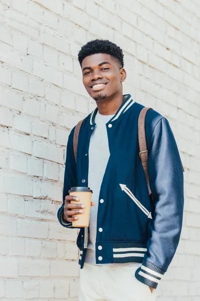 Стильний Усміхнений Афроамериканський Чоловік Тримає Одноразову Чашку Кавою Біля Білої — стокове фото