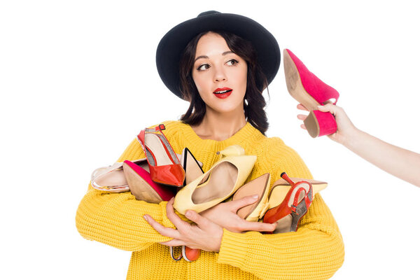 красивая модная девушка с обувью возле уха держа кучу высоких каблуков изолированы на белом
 