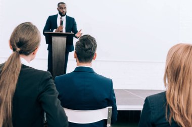 Seyirci konferans salonu önünde konuşurken yakışıklı Afro-Amerikan hoparlör