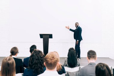 Konferans salonunda seminer sırasında hedef kitleye konuşuyor ve ekranda işaret Afro-Amerikan öğretim görevlisi gülümseyen