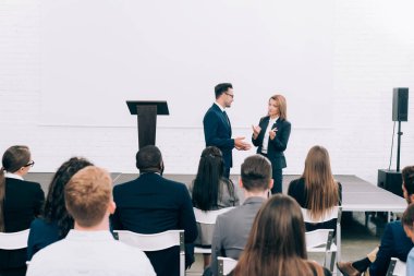 Konferans salonunda seminer sırasında çok kültürlü seyirci önünde konuşan arkadaşları