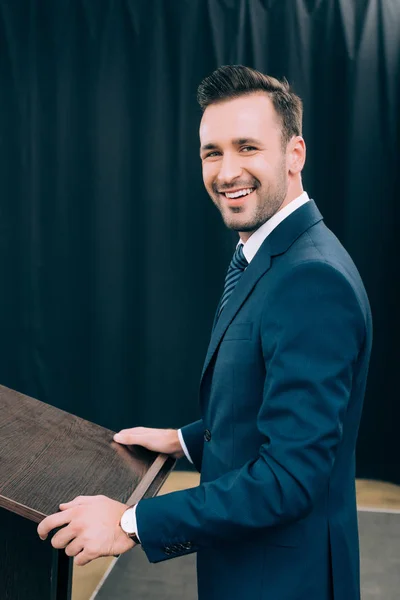 Smiling Speaker Standing Podium Tribune Seminar Conference Hall Looking Camera — Stock Photo, Image