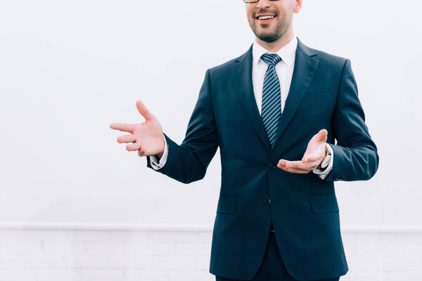 обрезанный образ улыбающегося докладчика, говорящего и жестикулирующего во время семинара в конференц-зале
