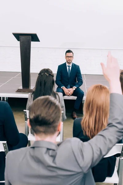 Back View Participant Raising Hand Lecturer Sitting Stage Conference Hall — Stock Photo, Image