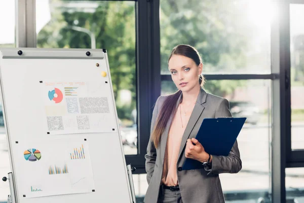 Vrouwelijke Business Luidspreker Met Notepad Wit Bord Tijdens Lezing Conferentiezaal — Gratis stockfoto