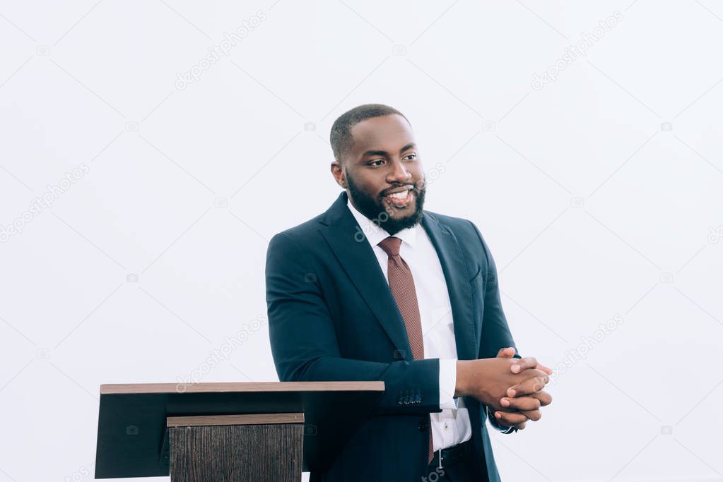 handsome smiling african american businessman talking during seminar in conference hall