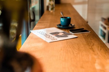 Smartphone, iş gazete ve kafe tabloda çay