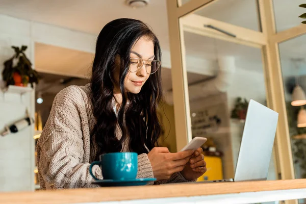 Уровень Поверхности Красивой Женщины Сидящей Кафе Ноутбуком Помощью Смартфона — Бесплатное стоковое фото