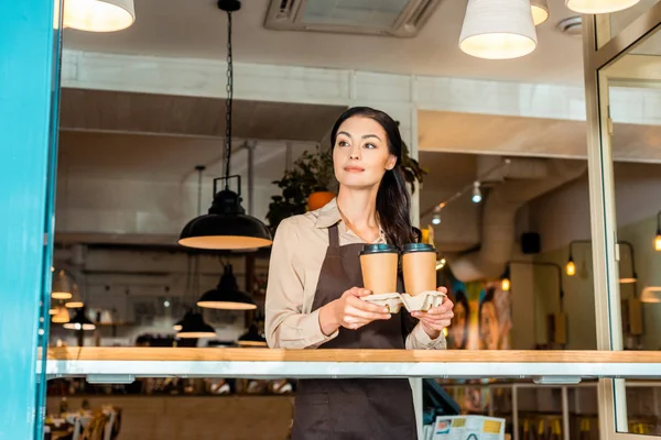 Hermosa Camarera Delantal Sosteniendo Café Tazas Papel Cafetería Mirando Hacia — Foto de Stock