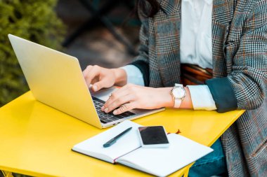 restoranın terasında günlüğü ve smartphone ile laptop ile çalışan iş Freelancer kısmi görünümü