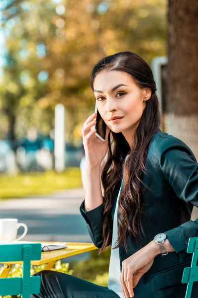 Beautiful Businesswoman Talking Smartphone Street Cafe Looking Camera — Free Stock Photo