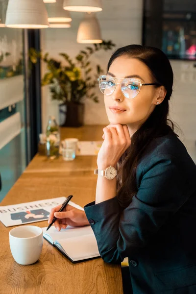 Όμορφη Freelancer Γράφοντας Στο Ημερολόγιο Στο Τραπέζι Καφέ Κύπελλο Και — Φωτογραφία Αρχείου