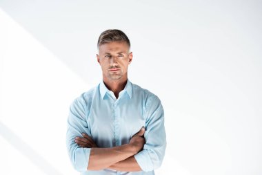 serious adult man in shirt looking at camera with crossed arms isolated on white clipart