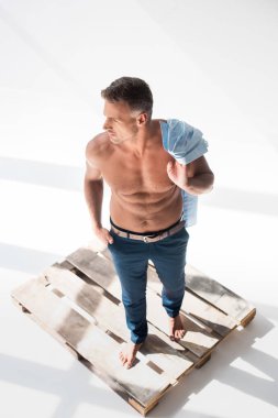 high angle view of shirtless sexy adult man standing on pallet on white clipart