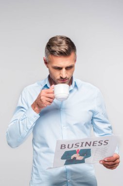 kahve içme ve üzerinde beyaz izole iş gazete okuyan yakışıklı yetişkin iş adamı