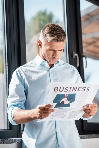 Serious Adult Businessman Reading Business Newspaper Front Window — Free Stock Photo