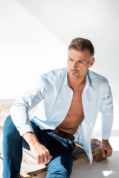 Homem Adulto Atraente Camisa Desabotoada Sentado Paletes Madeira Branco Olhando — Fotografia de Stock