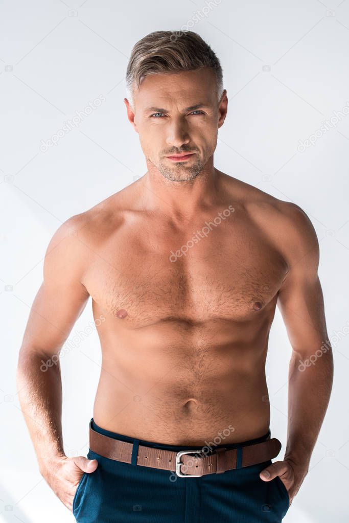 serious shirtless macho looking at camera isolated on white