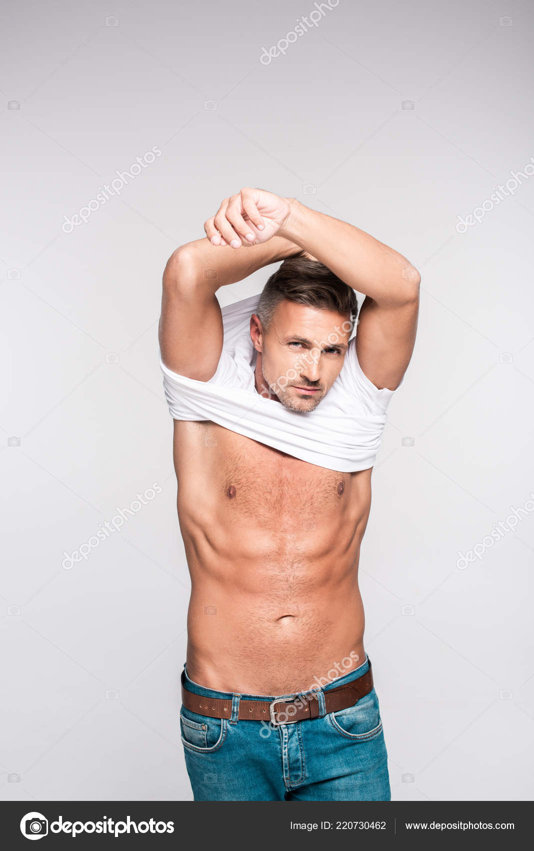 Handsome Sexy Man Taking Shirt Looking Camera Isolated Grey Stock by ©IgorVetushko 220730462