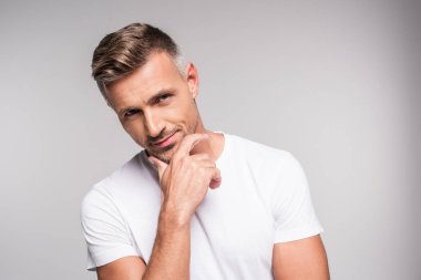 gri izole kamera gülümseyen çene üzerinde el ile yakışıklı adam portresi 