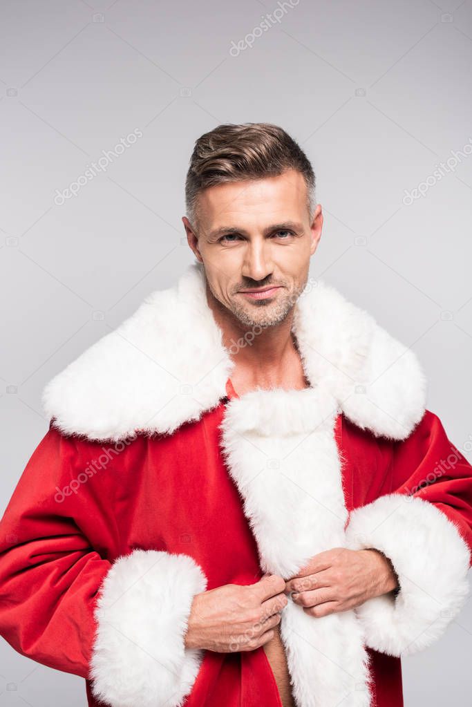 portrait of handsome man in santa costume smiling at camera isolated on grey