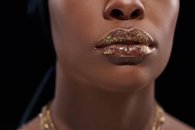 cropped shot of african american woman with sparkling lip gloss isolated on black