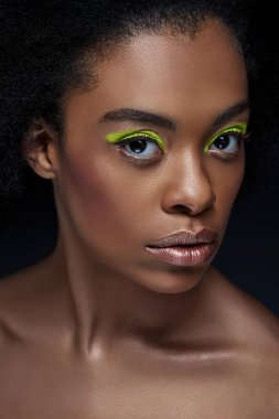 güzel Afro-Amerikan model parlak neon makyaj ve çıplak omuzları siyah izole ile portresi