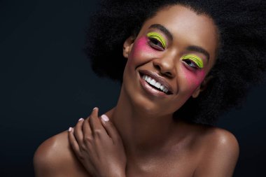 Afro-Amerikan modeli siyah izole makyaj parlak neon poz ile gülümseyen portresi