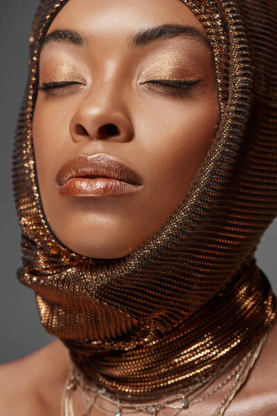 portrait of attractive african american model with head wrap and eyes closed isolated on grey