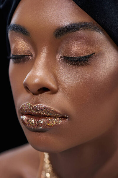 portrait of beautiful african american woman with eyes closed isolated on black