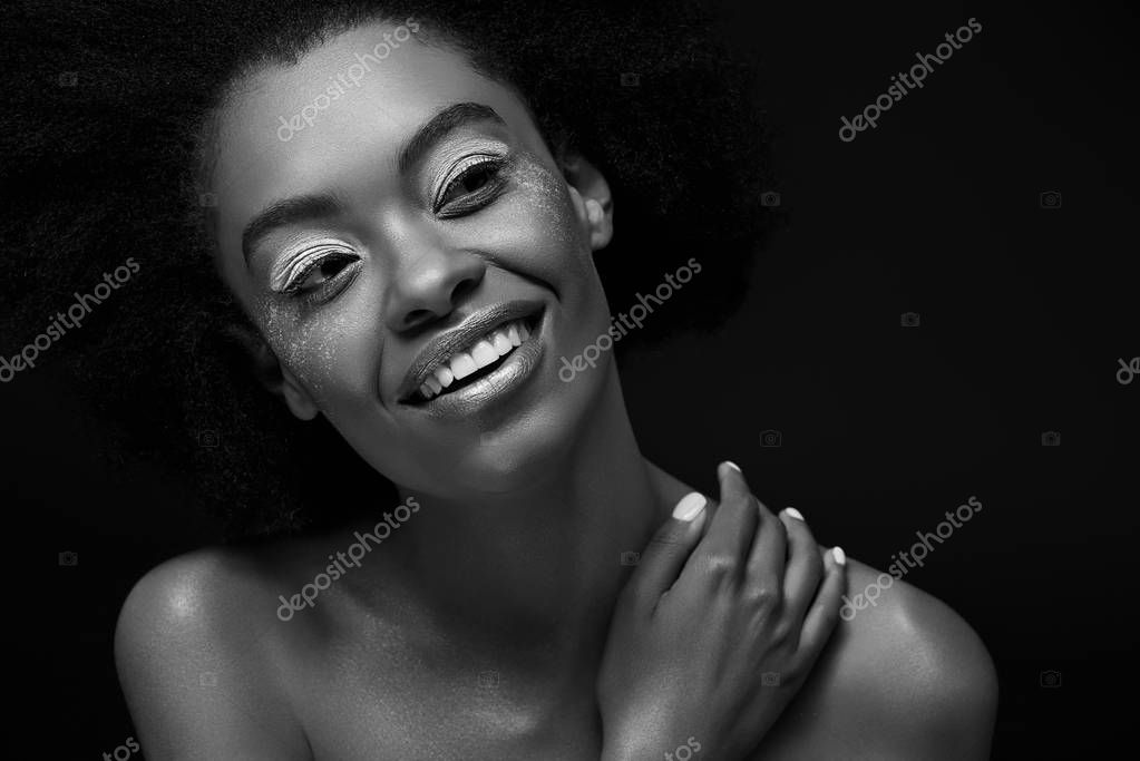 Black and white photo of attractive pensive african american woman looking away isolated on black