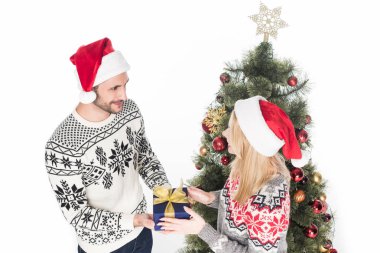 kadının erkek Noel ağacı üzerinde beyaz izole yakınındaki hediye sunmak yüksek açılı görünüş