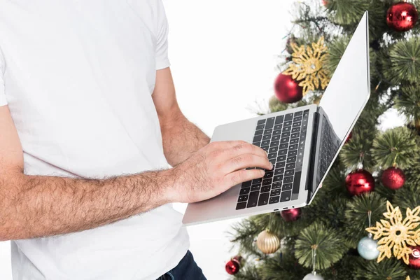 Oříznutý Snímek Člověka Pomocí Přenosného Počítače Poblíž Vánoční Stromeček Izolované — Stock fotografie zdarma