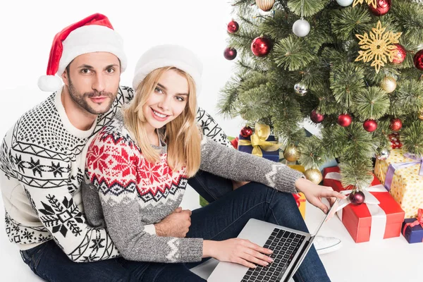 Jong Koppel Santa Claus Hoeden Met Laptop Buurt Van Kerstboom — Gratis stockfoto