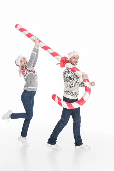 Joven Pareja Santa Claus Sombreros Suéteres Celebración Juguete Caramelo Aislado — Foto de stock gratis