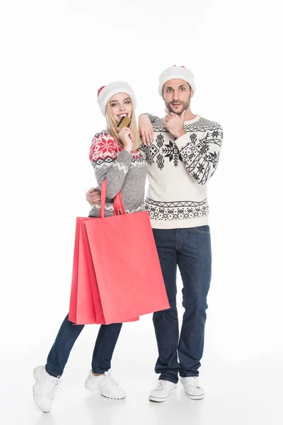 カップルで買い物袋と白で隔離クレジット カード サンタ クロース帽子  — 無料ストックフォト
