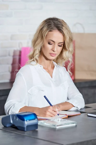 Junge Frau Schreibt Notizbuch Und Arbeitet Geschäft — Stockfoto