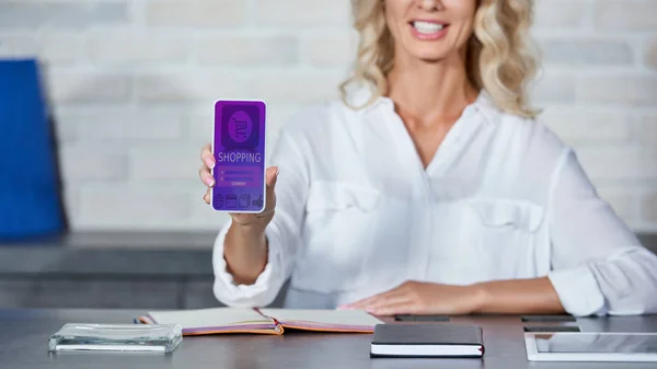 Recortado Disparo Joven Sonriente Sosteniendo Teléfono Inteligente Con Aplicación Compras —  Fotos de Stock