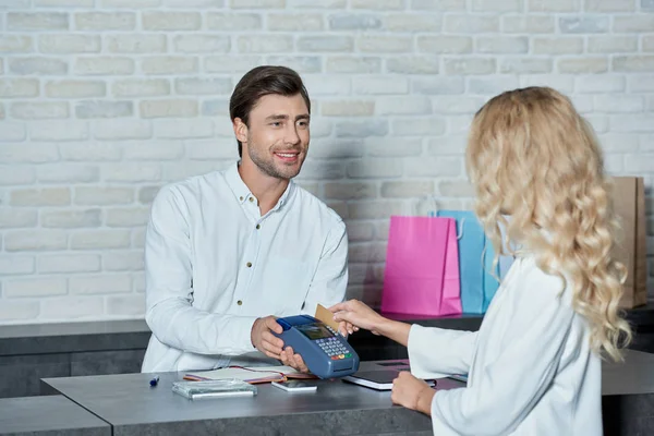 Hombre Sonriente Sosteniendo Terminal Pago Mujer Joven Pagando Con Tarjeta — Foto de Stock